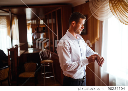 Luxury groom in suit. Businessman. Morning Groom Fees. The beginning of the wedding day. Men's fashion. Luxury groom in suit. Businessman. Morning Groom Fees. The beginning of the wedding day. Men's fashion. 98284304