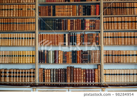 Old books on wooden shelf. Tiled Bookshelf background. historical old books in the old personal library. Concept on the theme of history, nostalgia, old age. Retro style. Selective focus. Old books on wooden shelf. Tiled Bookshelf background. historical old books in the old personal library. Concept on the theme of history, nostalgia, old age. Retro style. Selective focus. 98284954