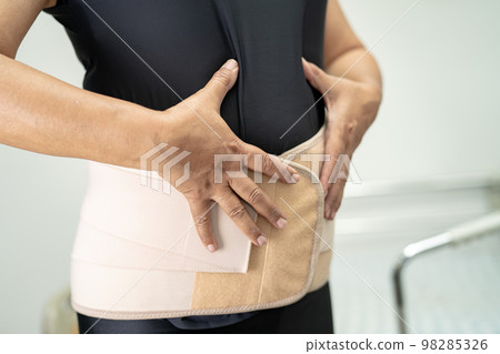 Asian lady patient wearing back pain support belt for orthopedic lumbar with walker. Asian lady patient wearing back pain support belt for orthopedic lumbar with walker. 98285326