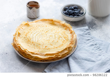 Vegetarian breakfast with crepes, thin pancakes on gray background Vegetarian breakfast with crepes, thin pancakes on gray background 98286122
