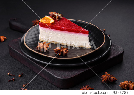 Delicious sweet cheesecake with raspberry jam on a black ceramic plate Delicious sweet cheesecake with raspberry jam on a black ceramic plate 98287851