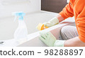 Middle-aged man cleaning the bathtub in the bathroom 98288897