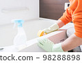Middle-aged man cleaning the bathtub in the bathroom 98288898