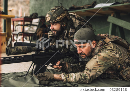 Soldier in camouflage preparing the rifle for shooting 98289118