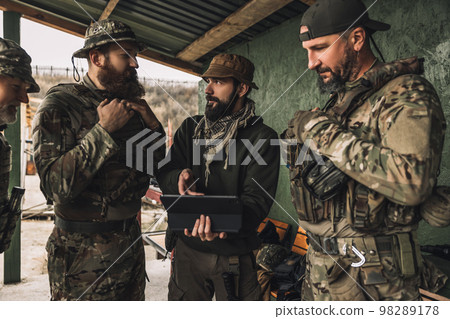 Group of soldiers discussing something before combat Group of soldiers discussing something before combat 98289178