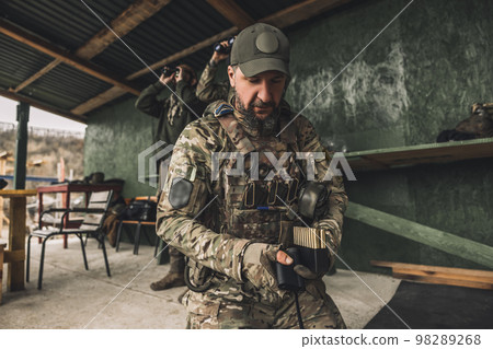 Serious soldier in camouflage with an optical rifle Serious soldier in camouflage with an optical rifle 98289268