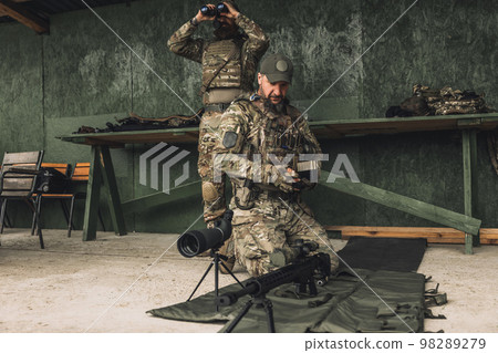 Serious soldier in camouflage with an optical rifle Serious soldier in camouflage with an optical rifle 98289279