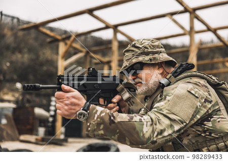 Mature soldier with a rifle in hands on a shooting range 98289433