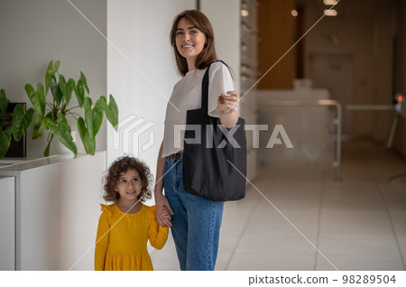 Mom and a little girl in the hotel looking glad 98289504