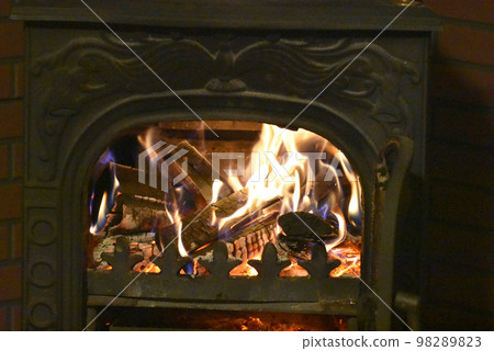 Burning a wood stove in a log house villa 98289823