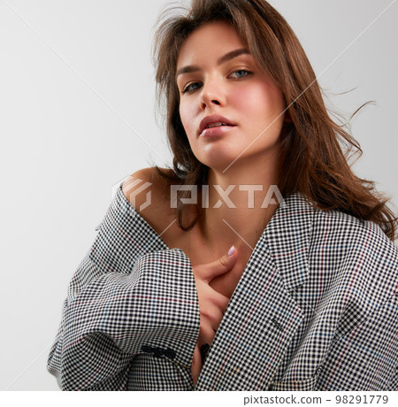 Portrait of young beautiful girl wearing stylish oversize jacket isolated over white background. Concept of beauty, fashion, human emotions Portrait of young beautiful girl wearing stylish oversize jacket isolated over white background. Concept of beauty, fashion, human emotions 98291779
