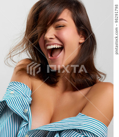 Laughing. Sensual adorable young woman with perfect skin, natural make-up with bare shoulders over light background. Concept of emotions, facial expression, fashion. 98291798
