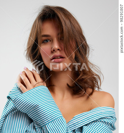 Sensual adorable young woman with perfect skin, natural make-up in striped shirt expressing different emotions over light background. Concept of emotions, facial expression, fashion. Sensual adorable young woman with perfect skin, natural make-up in striped shirt expressing different emotions over light background. Concept of emotions, facial expression, fashion. 98291807