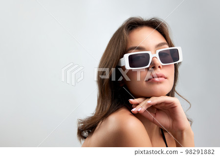 Self-confidence. Young stylish beautiful girl in fashionable eyewear isolated over grey background. Concept of beauty, skin care, cosmetology, fashion 98291882