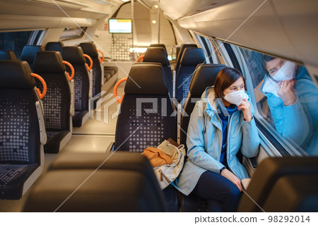 Asian Woman looking out of train window in winter day 98292014