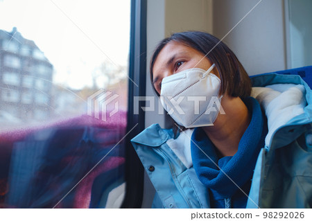 Asian Woman looking out of train window in winter day Asian Woman looking out of train window in winter day 98292026