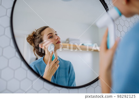 Young woman taking care of her skin, morning beauty routine concept. 98292125