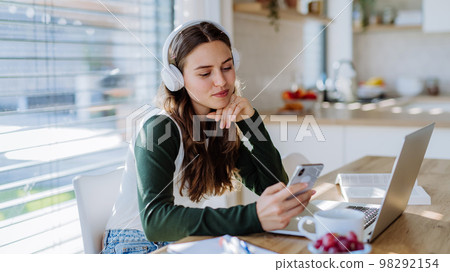 Young woman having distance education in her apartment. 98292154