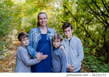 Portrait of pregnant mother and her three sons, outdoor in forest. Portrait of pregnant mother and her three sons, outdoor in forest. 98292255