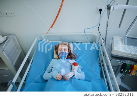 Close-up of little girl with infection disease lying in hospital room. 98292311