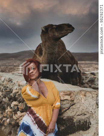 woman in a desert landscape with camels woman in a desert landscape with camels 98292371