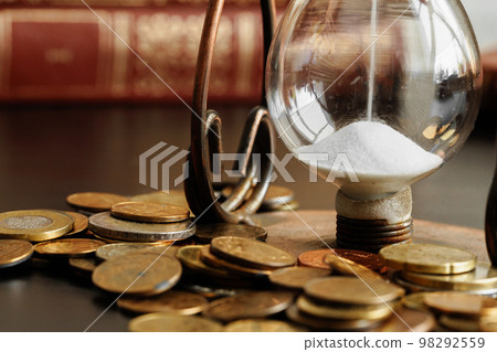 Time is money. Close up of hourglass with money coins 98292559
