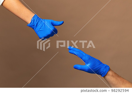 Male and female hands in medical gloves stretch to each other. Help concept. 98292594