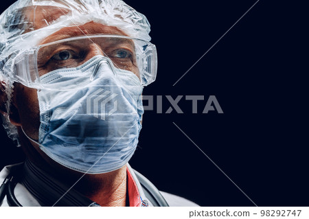 Male doctor wearing protective Mask and Goggles. Dark background. Male doctor wearing protective Mask and Goggles. Dark background. 98292747