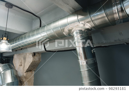 Silver ventilation pipes hanging from the ceiling inside the building Silver ventilation pipes hanging from the ceiling inside the building 98293181