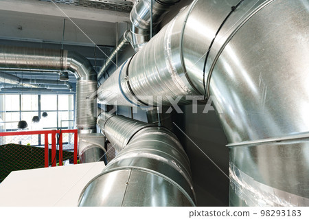 Silver ventilation pipes hanging from the ceiling inside the building Silver ventilation pipes hanging from the ceiling inside the building 98293183