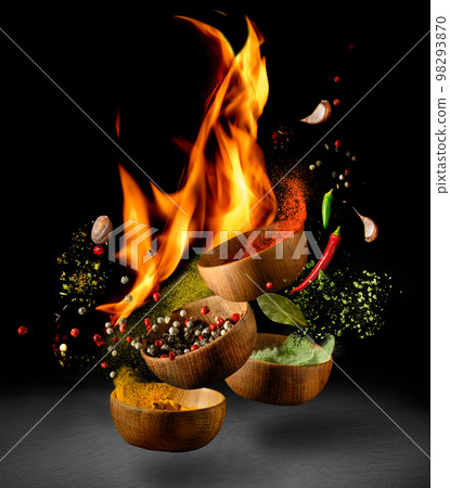Hot Spices and seasonings powder splash, explosion on black background with flame 98293870