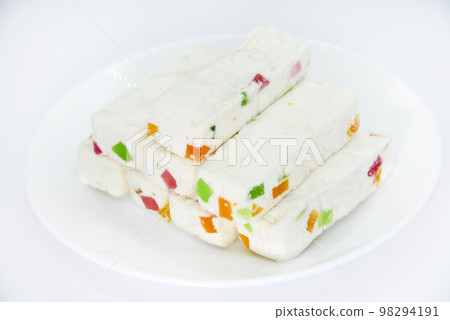 Pieces of juicy marshmallow on a white plate. Sweet oriental snack. Sweets for tea. 98294191
