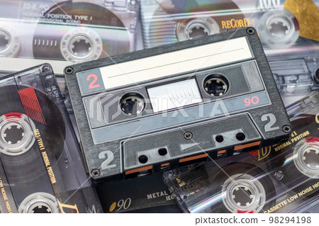 One audio cassette tape on a pile of audio cassettes lying on top of each other One audio cassette tape on a pile of audio cassettes lying on top of each other 98294198