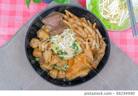 Chicken noodles with chicken feet, chicken thighs, chicken joints and side vegetables, bean sprouts, sliced bitter gourd. 98294990