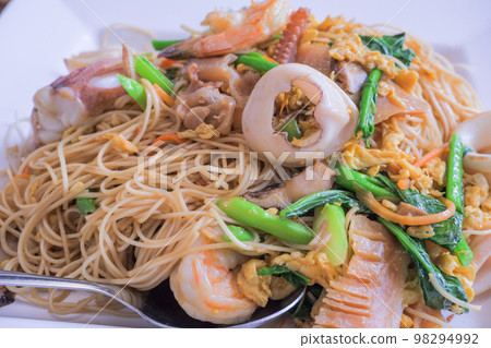 Hong Kong recipe stir-fried noodles with egg, fresh squid, shrimp, pickled squid and Hong Kong vegetables. 98294992