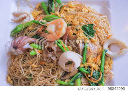 Hong Kong recipe stir-fried noodles with egg, fresh squid, shrimp, pickled squid and Hong Kong vegetables. 98294993