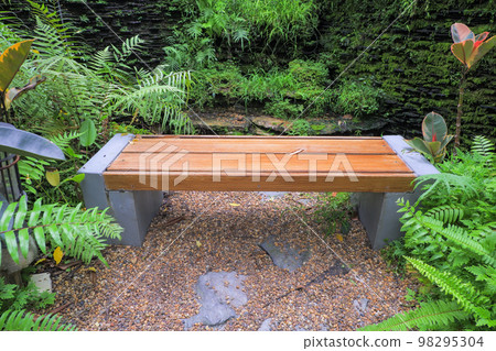 Chairs made of mortar destroyed like wood in a public garden. The surrounding area is full of small trees. make the atmosphere relax. Chairs made of mortar destroyed like wood in a public garden. The surrounding area is full of small trees. make the atmosphere relax. 98295304