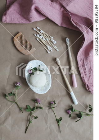Soap bar or solid shampoo on a soap dish, bamboo toothbrush and towel top view with copyspace. Accessories for personal hygiene. Plastic free and eco friendly products in household Soap bar or solid shampoo on a soap dish, bamboo toothbrush and towel top view with copyspace. Accessories for personal hygiene. Plastic free and eco friendly products in household 98295594