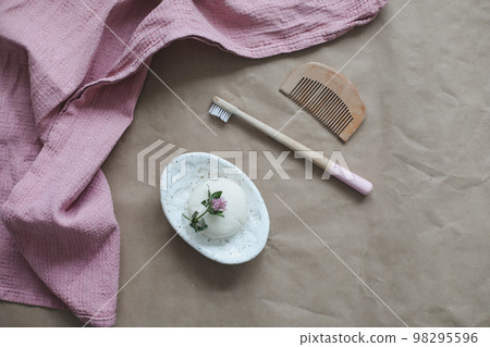 Soap bar or solid shampoo on a soap dish, bamboo toothbrush and towel top view with copyspace. Accessories for personal hygiene. Plastic free and eco friendly products in household Soap bar or solid shampoo on a soap dish, bamboo toothbrush and towel top view with copyspace. Accessories for personal hygiene. Plastic free and eco friendly products in household 98295596