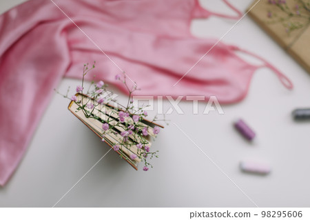Flat lay composition with elegant pink dress, book, flowers on white background top view Flat lay composition with elegant pink dress, book, flowers on white background top view 98295606