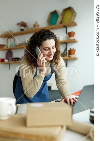 Young woman run pottery business, focused busty female entrepreneur, produce ceramic items. Small business and entrepreneurship in art, self-employment. Home office Young woman run pottery business, focused busty female entrepreneur, produce ceramic items. Small business and entrepreneurship in art, self-employment. Home office 98295875