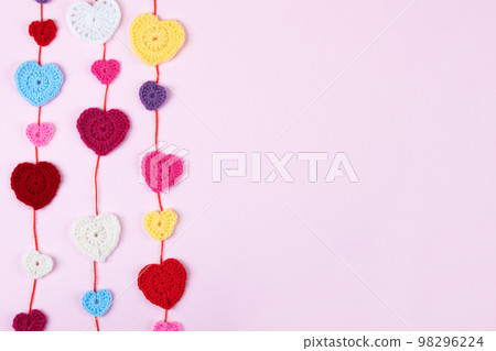 Multicolored crocheted hearts on a lilac background with space for text. Happy Valentine's Day, Mother's Day and birthday greeting card. Multicolored crocheted hearts on a lilac background with space for text. Happy Valentine's Day, Mother's Day and birthday greeting card. 98296224