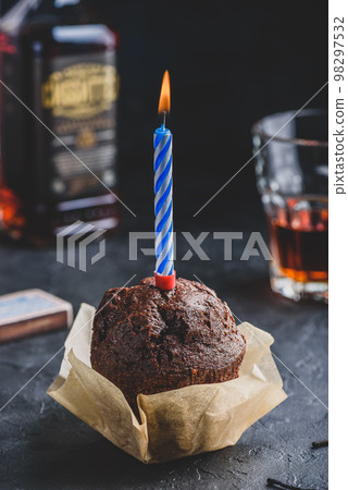 Chocolate muffin with birthday candle 98297532