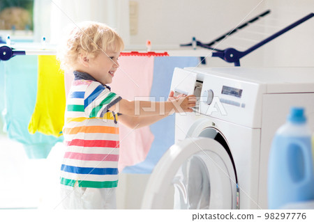 Child in laundry room with washing machine 98297776