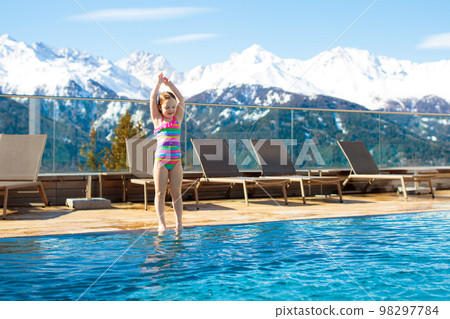 Child in outdoor swimming pool of alpine resort Child in outdoor swimming pool of alpine resort 98297784