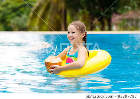 Child with coconut drink. Kids in swimming pool. Child with coconut drink. Kids in swimming pool. 98297785