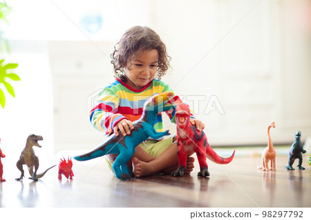 Child playing with toy dinosaurs. Kids toys. 98297792