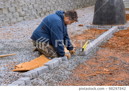 Pavers stone pathway paving master lays paving stones by using professional paver worker Pavers stone pathway paving master lays paving stones by using professional paver worker 98297842