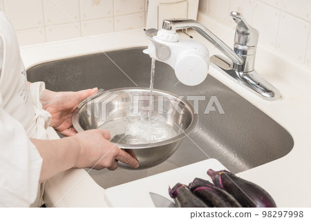 [A middle-aged housewife puts water in a bowl to remove scum] 98297998