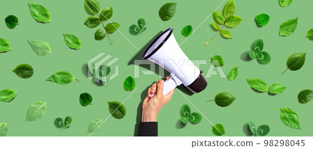 Person holding a megaphone with green leaves 98298045